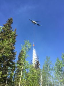 A helicopter drops a 300-gallon bucket of water on the Ohio Creek Fire off Standard Creek Road, about 20 miles southwest of Fairbanks on Thursday afternoon. Tasha Shields/Alaska Division of Forestry