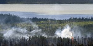 A helicopter equipped with a water dropping bucket douses hotspots on the Tetlin River Fire on Tuesday, June 21, 2016. Photo by Sam Harrel/Alaska Division of Forestry