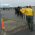 Emergency firefighter crews from Chevak, Hooper Bay, Huslia and Kaltag line up to board a jet that will take them to the Lower 48 to work on wildland fires. Photo by Darla Theisen/Alaska Division of Forestry