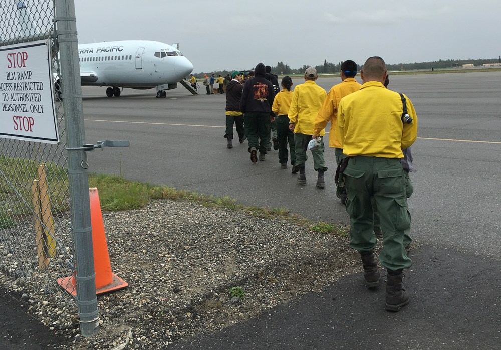 Emergency firefighter crews from Chevak, Hooper Bay, Huslia and Kaltag line up to board a jet that will take them to the Lower 48 to work on wildland fires. Photo by Darla Theisen/Alaska Division of Forestry