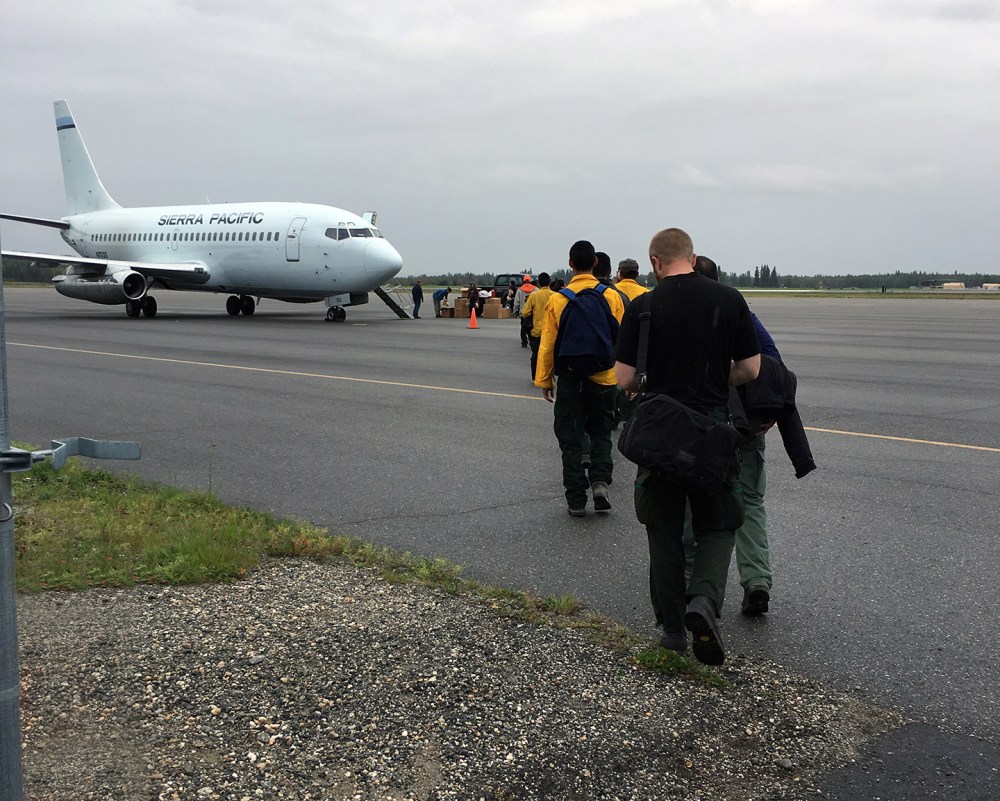 Emergency firefighter crews from Chevak, Hooper Bay, Huslia and Kaltag line up to board a jet that will take them to the Lower 48 to work on wildland fires. Photo by Darla Theisen/Alaska Division of Forestry