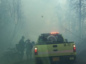 Two firefighters talk to a crew in a Division of Forestry engine on Sunday at the Moose Creek Fire near Sutton. The fire is now estimated at 300 acres and is 25 percent contained. Photo by Sarah Saarloos/Alaska Division of Forestry 
