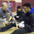 Instructor Ben Ferguson, on left, helps Alaska Job Corps student Esai Montes as he and fellow student Ying Yang learn to sharpen pulaskis during a basic wildland firefighting class on Feb. 8, 2017