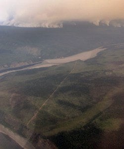 The Campbell River Fire burns to the southwest of the confluence of the Salmon Trout and Porcupine rivers Thursday, July 13, 2017, near the Canadian border in northeast Alaska. A fire break is visible in the foreground cut to protect Native allotments and the historic area of Old Rampart, an area from the days of riverboat trade between fur buyers and local trappers. James Higgins / BLM Alaska Fire Service