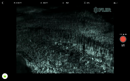 This screen shot shows what pilots see on the control monitor during an infrared flight. The bright white spots are hot spots on the edge of a fire.