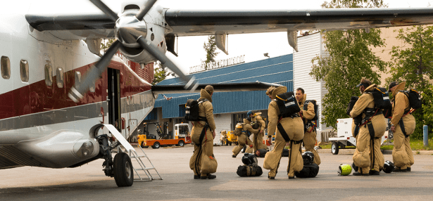 Smokejumpers check each other's equipment before boarding an airplane bound for the William Slough Fire (#220) Saturday afternoon. Four smokejumpers parachuted in to set up protection measures on a cabin about a mile away from the fire while other four returned to the Alaska Smokejumper base at BLM AFS facilities on Fort Wainwright. Photo by Beth Ipsen, BLM AFS