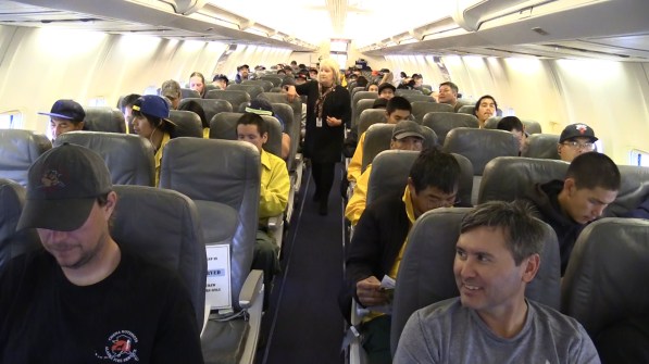 Four Type 2 emergency firefighter crews and supporting agency appointed overhead sit on a plane before flying to the Lower 48 to help with the busy fire season. Photo by Beth Ipsen, BLM AFS