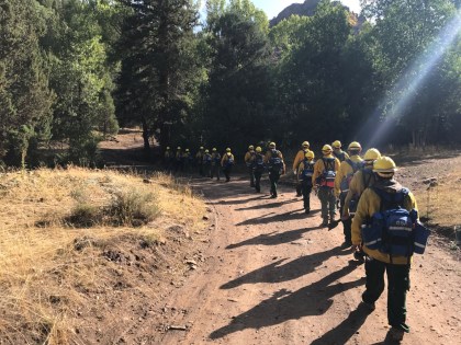 Photo of Emergency firefighters on the Yukon Flats crew walk to the fireline while on a fire in the Lower 48 in 2018.