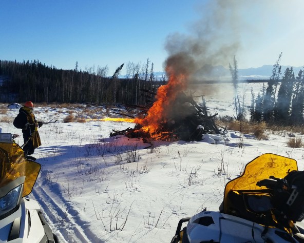 Photo of A BLM AFS firefighter uses a Terra Torch to light a woody pile during a prescribed burn in the Donnelly Training Area in February 2019. On average, the piles measured 15-feet-by-15-feet and 15-feet tall. Photo by Chris Demers, BLM AFS