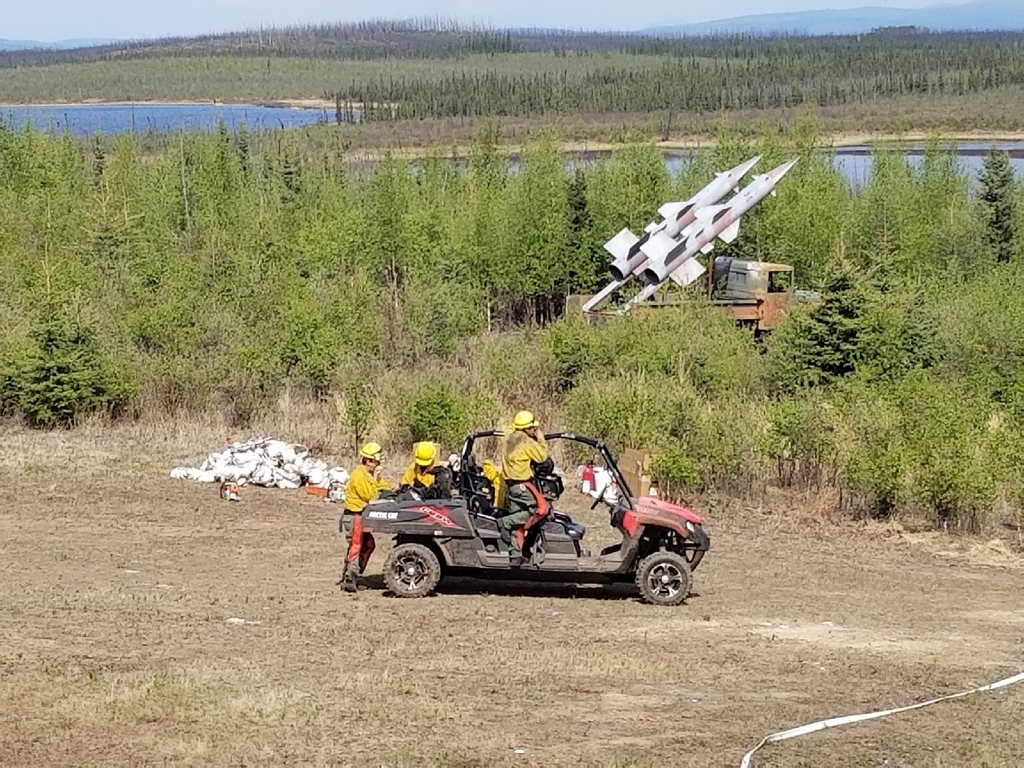 Photo of the Type 2 Emergency Firefighter Fairbanks #1 hand crew with some mock warfare infrastructure at the military observation sites north of the Oklahoma Range on the west side of Donnelly Training Area West.