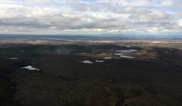 In this photo taken near the southern end looking north shows puffs of smoke from where the fire is smoldering along the timber edge on May 8, 2019. Photo by Isaiah Fischer, BLM AFS