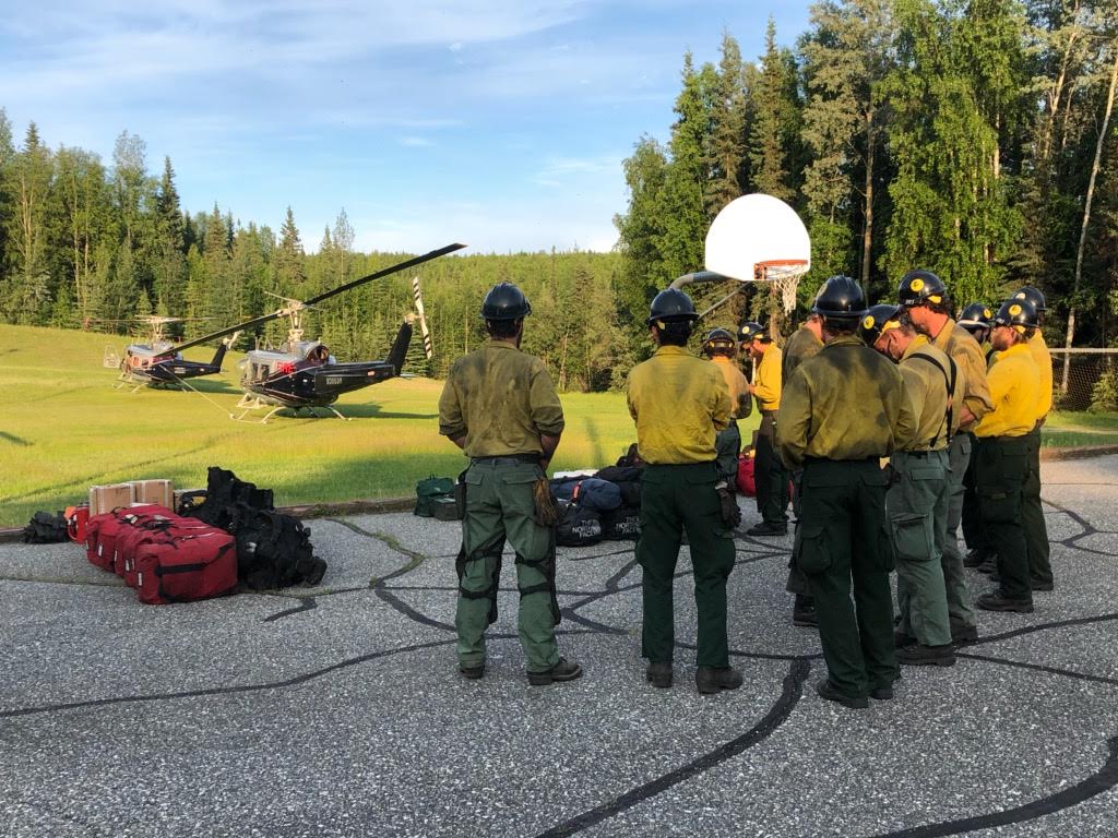 Photo of the BLM Alaska Fire Service Chena Interagency Hotshot Crew as they wait to be shuttled from the staging area at the Two Rivers Elementary School to the Caribou Creek Fire (#255) on June 16, 2019. Photo by Tim Mowry, DOF