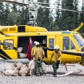 Firefighters remove equipment and garbage on July 27, 2019 from the Hadweenzic River Fire after it no longer needed.