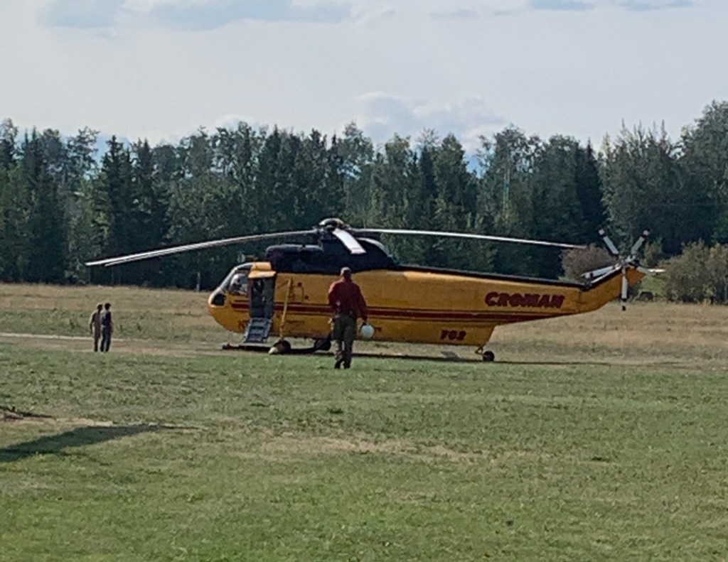 Photo of Sikorsky 63 heavy helicopter with crewmembers preparing to launch.