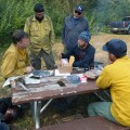 Initial Attack Incident Commander Tamar Young, seated in middle, briefs Cary Neu, incoming Division Supervisor with the NW Incident Management Team #10, seated on left, on Tuesday, August 20, 2019 as management of the fire transitions to the new team. Photo by Alan Hoffmeister/Team 10 Information Officer