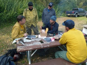 Initial Attack Incident Commander Tamar Young, seated in middle, briefs Cary Neu, incoming Division Supervisor with the NW Incident Management Team #10, seated on left, on Tuesday, August 20, 2019 as management of the fire transitions to the new team. Photo by Alan Hoffmeister/Team 10 Information Officer