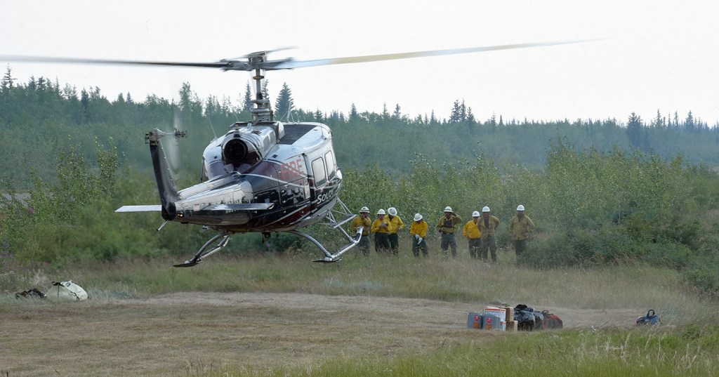 A bell 205 helicopter lands to pick up waiting members of the Chief Mountain Hotshot Crew at the Chalkyitsik helibase Sunday, July 14, 2019. The crew was being transported to the Chahalie Lake area near the Frozen Calf Fire (#367). The crew from Montana completed an assignment on the Shovel Creek Fire (#319), returned home for two days off and are now back in Alaska. Sam Harrel/Alaska Interagency Incident Management Team