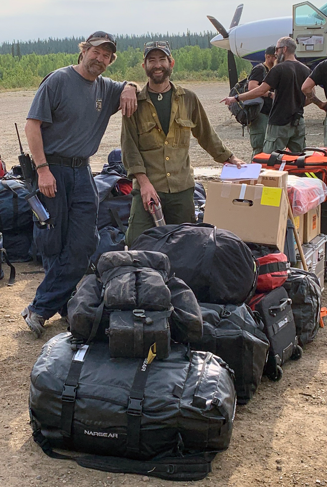 Photo of Colorado Line Medic Ernie Walker and Alaska Fire Medic Evan Sterling and their massive pile of equipment as they wait to demobilize from the Chalkyitsik Complex on Aug. 12, 2019.