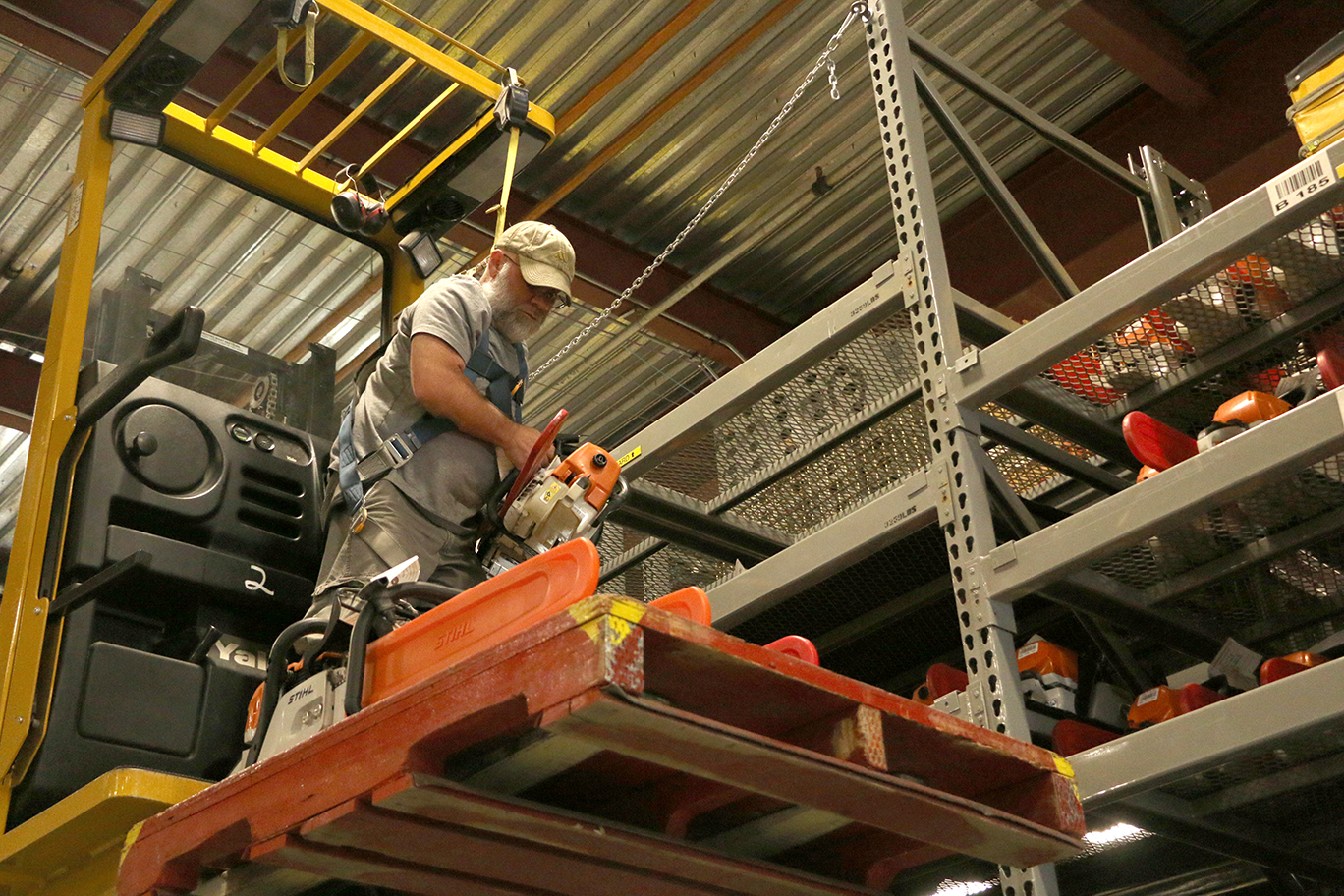 Materials Handler Rod Johnson retrieves chainsaws from the shelves for chainsaw kits that will go out to a fire.