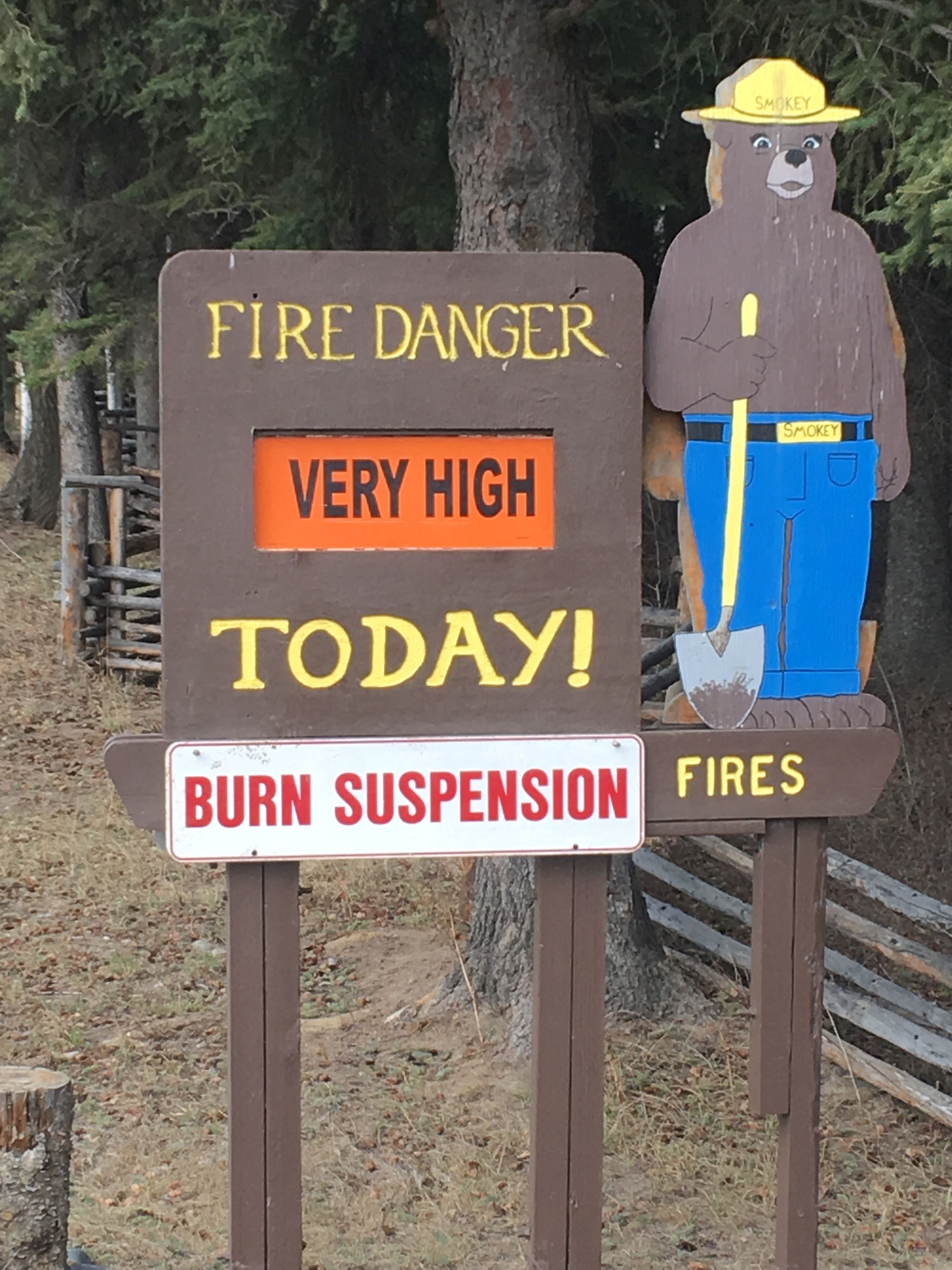 Photo of Smokey Bear wooden sign stating fire danger is very high today and burn suspensions are in place.