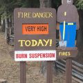 Photo of Smokey Bear wooden sign stating fire danger is very high today and burn suspensions are in place.
