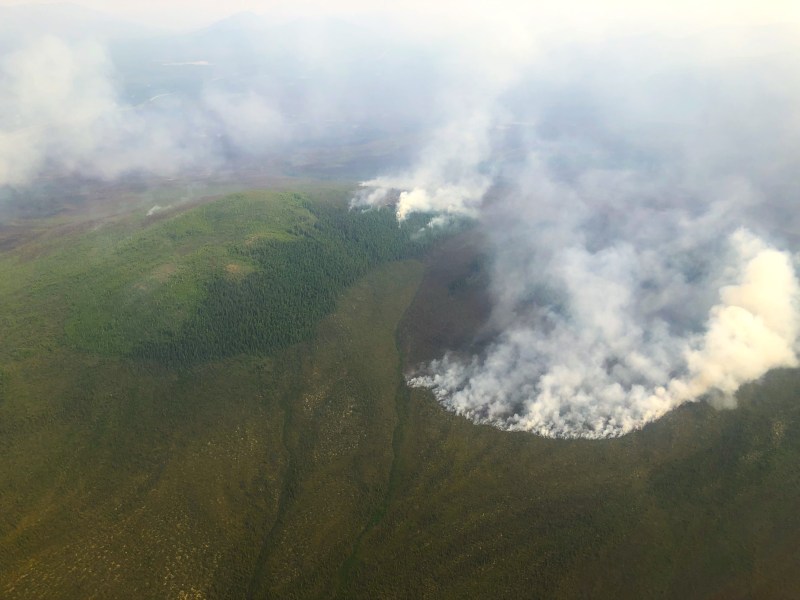 Mountain with fire and heavy smoke on top.