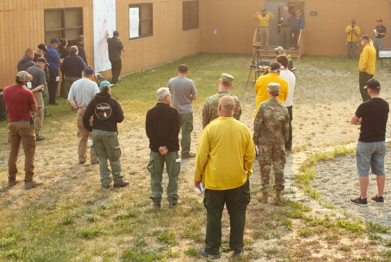 Incident management team members brief fire personnel on the morning of July 4, 2022. 