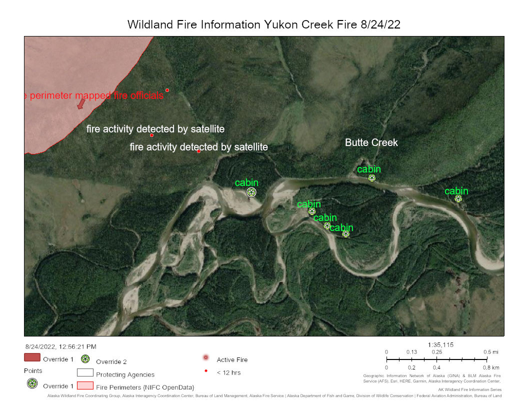 Satellite map showing a fire perimeter with red dots outside the perimeter indicating recent fire activity north of cabins along a river corridor.