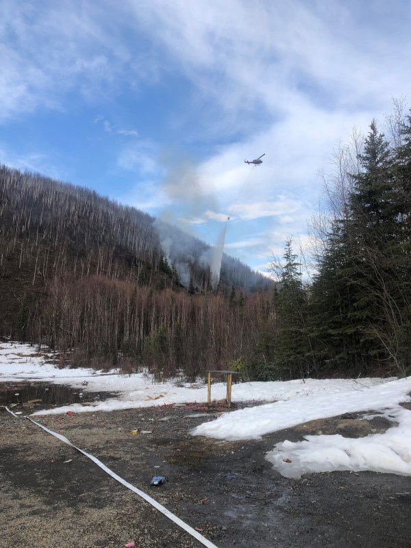 A responding helicopter drops a bucket of water on the Chena Hot Springs Range Fire 
