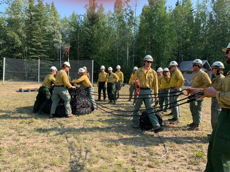 Firefighters load nets for a helicopter sling load.