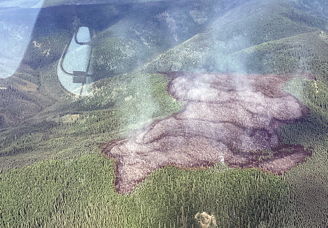 A large blackened area marks the area where a fire burned on top of a ridge line.