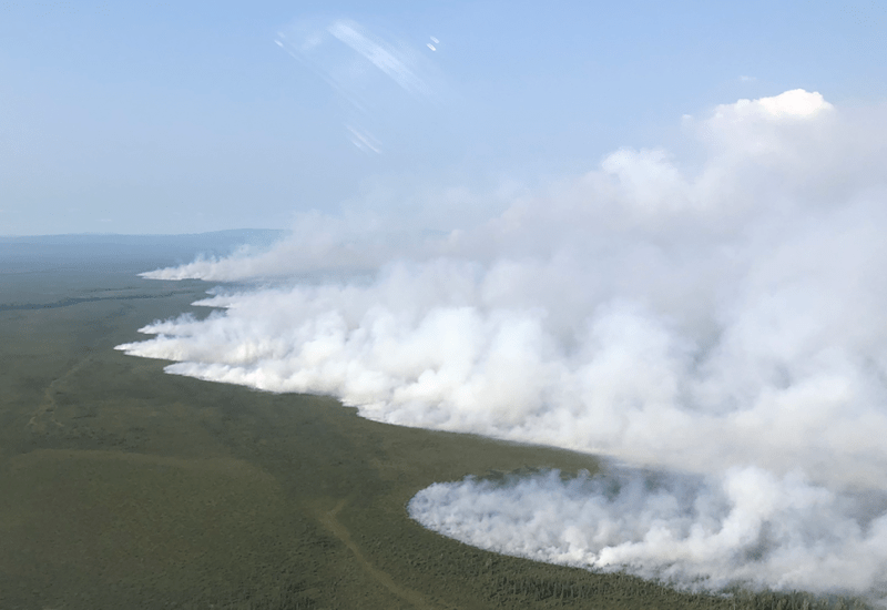 A smoke filled landscape burning in a green land.