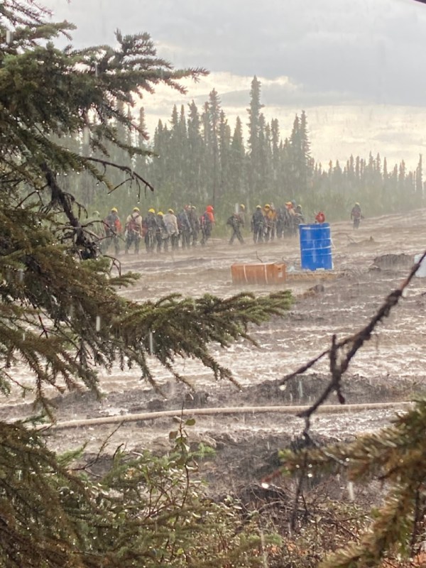 A group of firefighters caught in a downpour of rain.