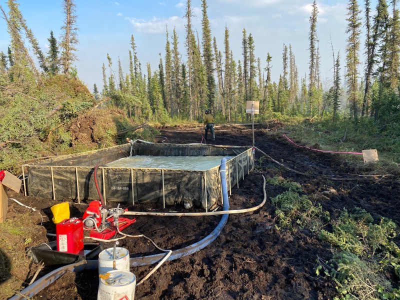 Containment operations with water tanks, pumps, and hose are used on the fire line by crews on the Pogo Mine Road (#191) fire.