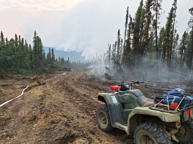 Bulldozed control line with fire nearby,