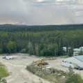 A smoke column with a forest and an equipment field near the Gerstle River.