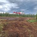 A helicopter lands on a fuel break.
