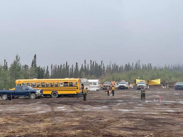 Fire crews in a muddy parkinig lot.