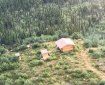 Aerial view of a cabin in the forest.