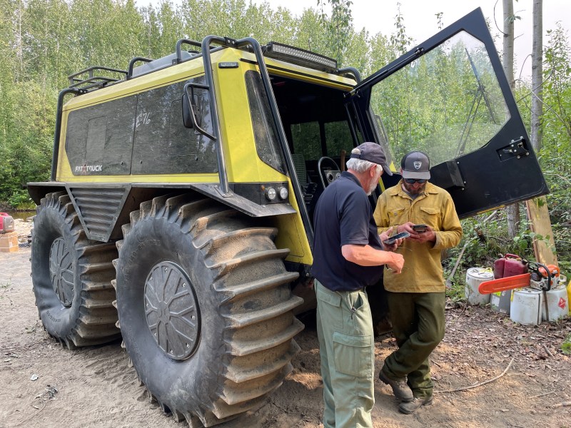 Public Information Officer Nate Leising speaks with Mark Johnson, Fat Truck operator Mark Johnson. The Fat Truck is used to haul personnel and equipment between the remote properties in the Clear Sky Homesteads. It can safely navigate rutted, uneven, and boggy trail conditions.