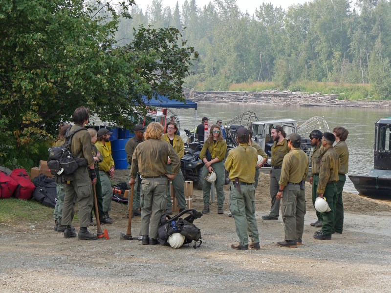 Fairbanks based White Mountain firefighters briefing at the Salcha Boat Ramp before deploying to their worksite on the fire line up the Salcha River. Firefighters and support personnel are relying on boats to travel up and down the river as they work on structure protection and containment lines. Ari Lightsey, AK DOF