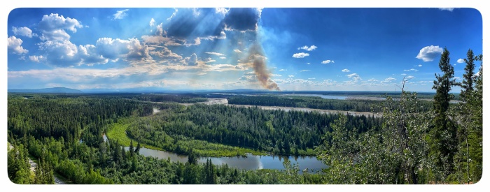 Mostly sunny skies looking across the Tanana River. Smoke is rising in the center.r