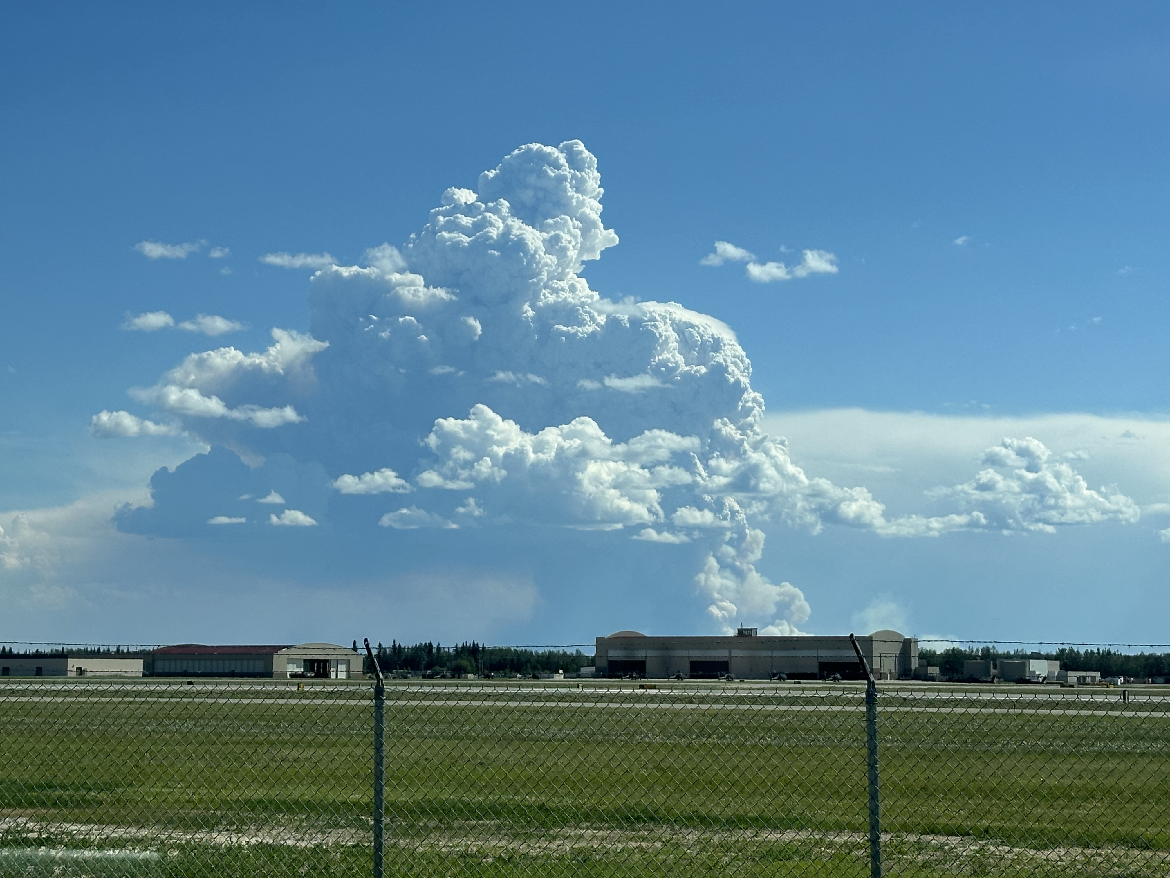 A large column of smoke and clouds looming over the landscape in this photo taken from the BLM AFS facilities on Fort Wainwright.
