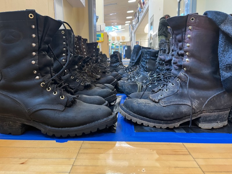 Firefighters take an opportunity to dry out their boots after being in wet muddy conditions all day.