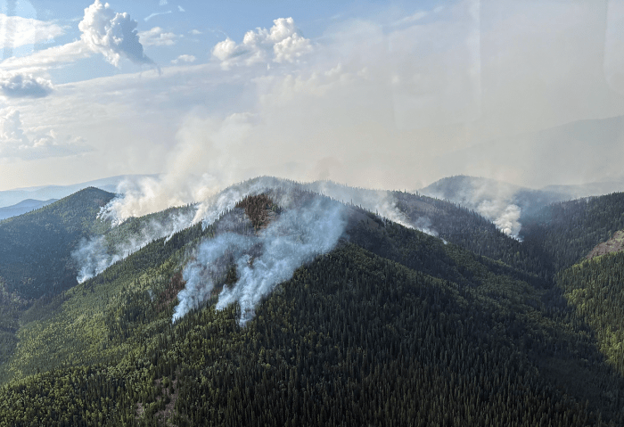 Fire drifting up from a burned area along ridgelines.