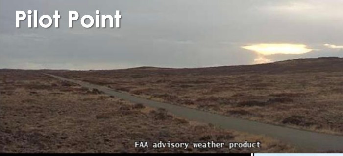 An airstrip and rolling mountain scape with the surrounding area covered in dry brown grass and brush.