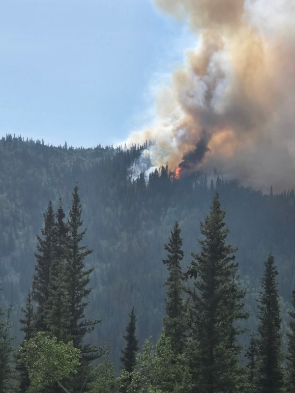 Image of flames on top of a ridge with smoke rising