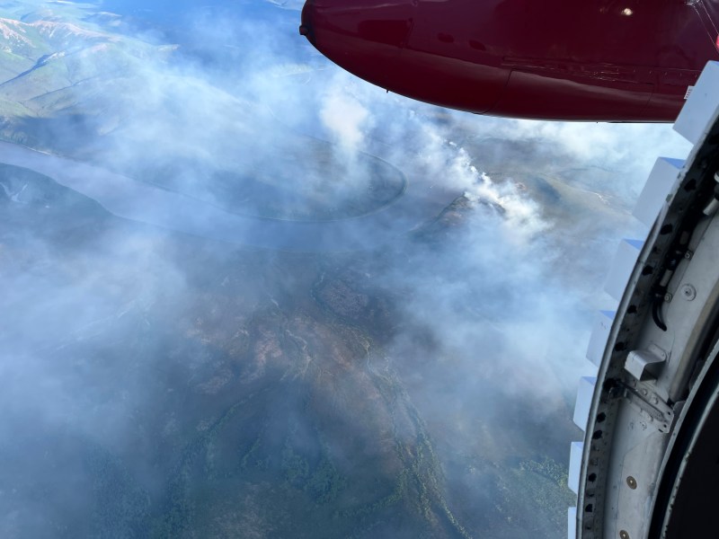 An aerial photo of a burned fire area with smoke coming off it