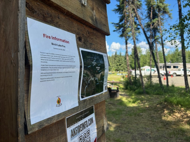 Photo of printed information attached to a cabin at the Birch Lake boat launch. Fire vehicles can be seen in the background.