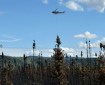 A helicopter drops buckets of water on a fire.